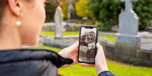 A woman uses an augmented reality app on her phone to take part in a historical walking tour of Fawkner Memorial Park in Melbourne's northern suburbs. (Adrian Vittorio)