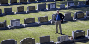 Elderly man posing in full cemetery